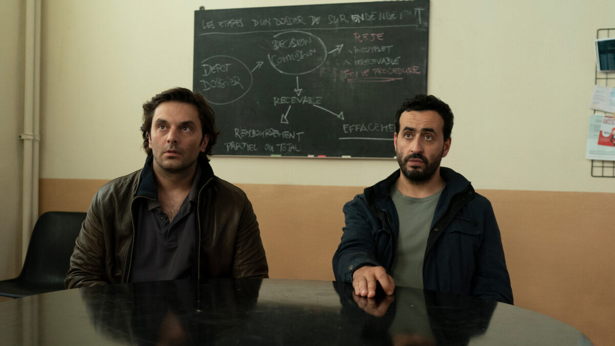 Dwójka mężczyzn przy stole w sali konferencyjnej.