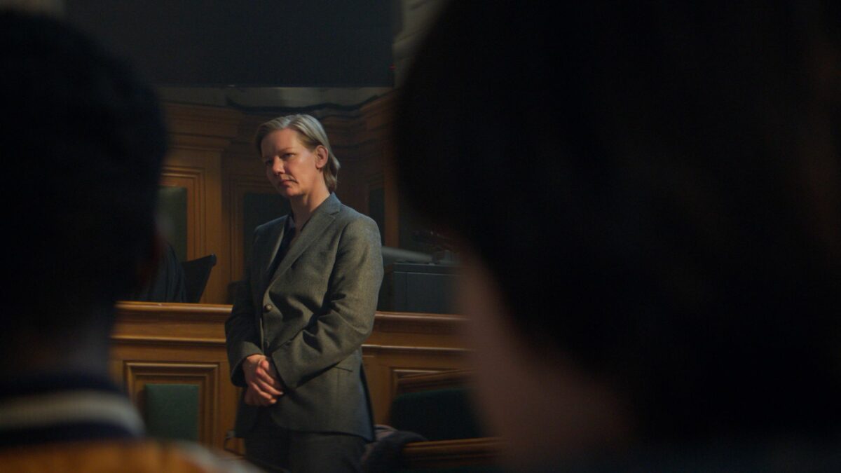 Zbliżenie na kobietę podczas rozprawy w sali sądowej.