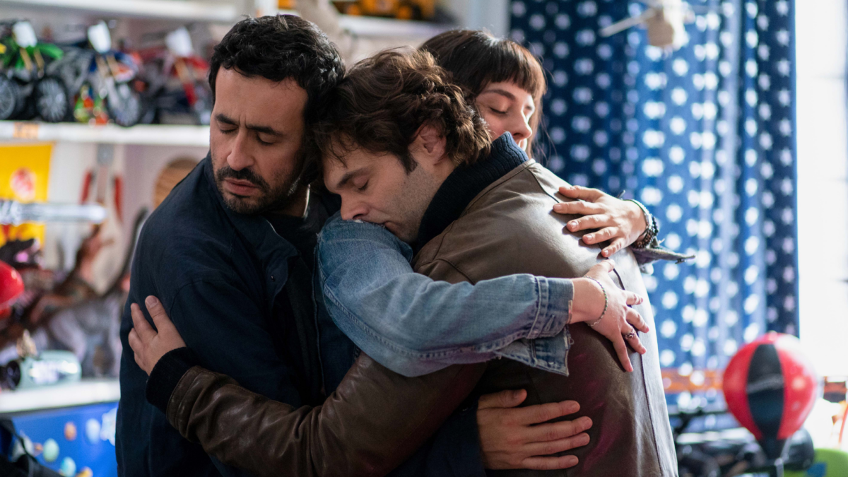 Trójka młodych przyjaciół przytulająca się do siebie.