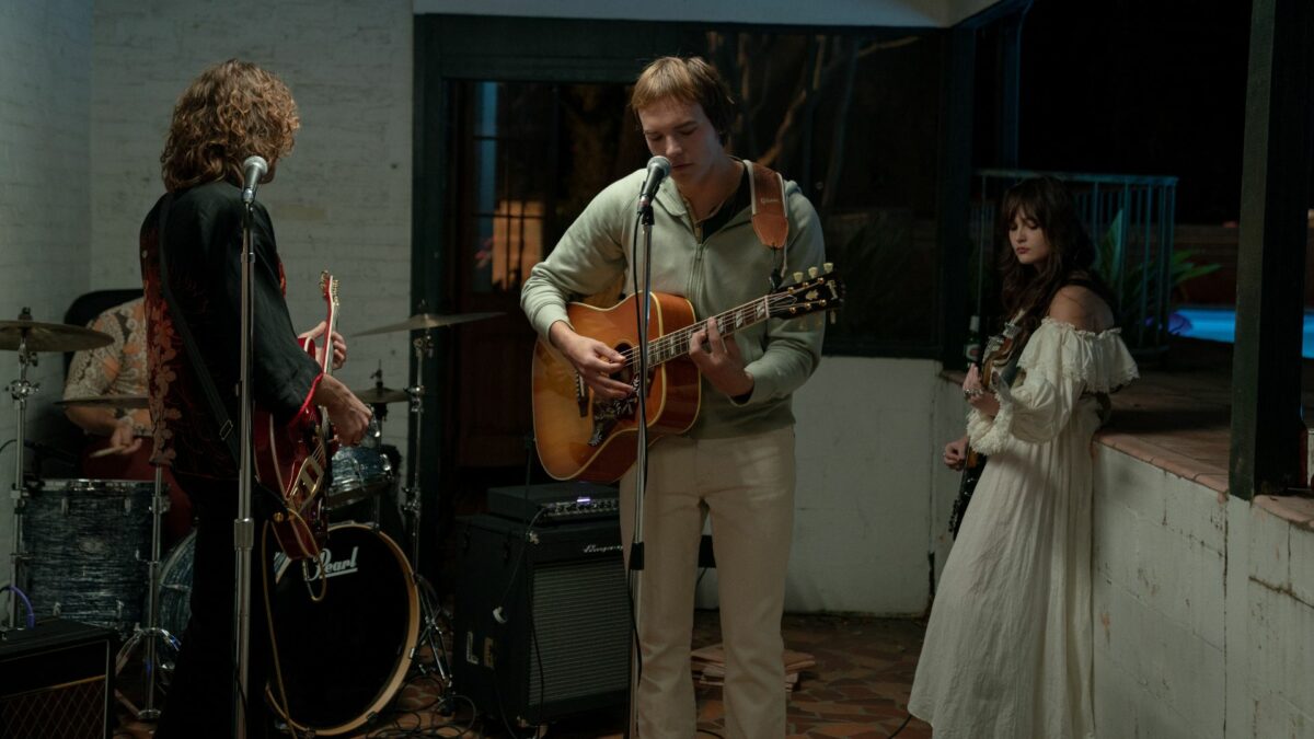 Kadr pokazujący próbę zespołu muzycznego w garażu.