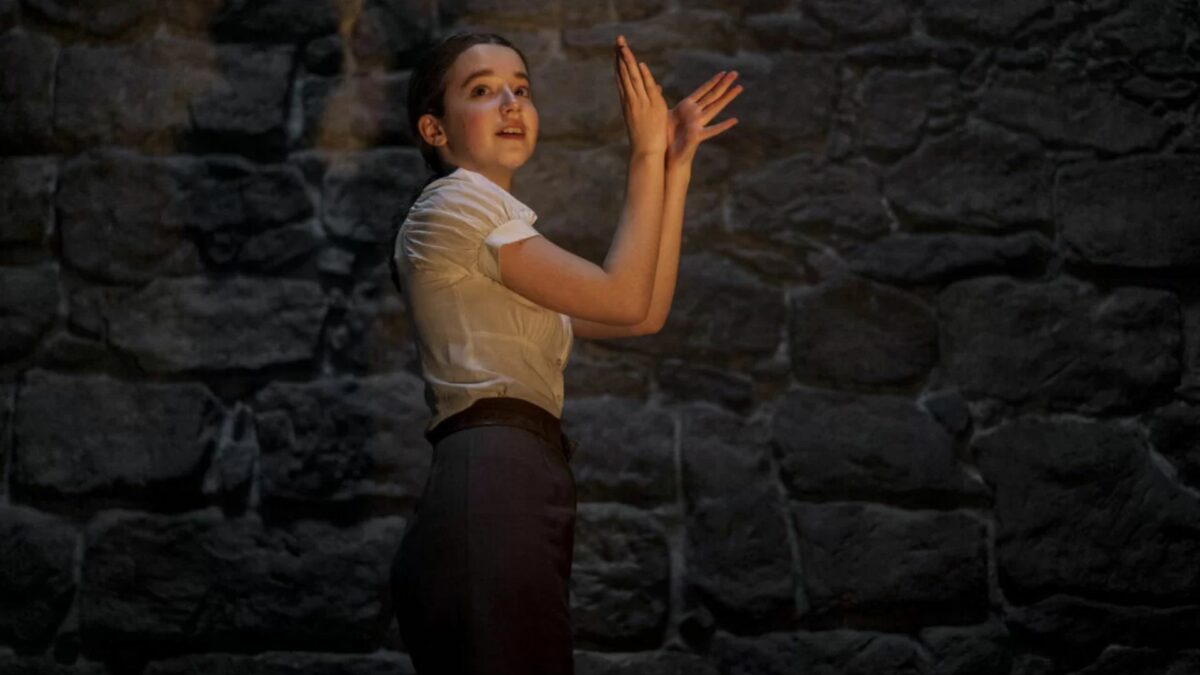 Młoda dziewczyna bawi się w teatrzyk cieni.