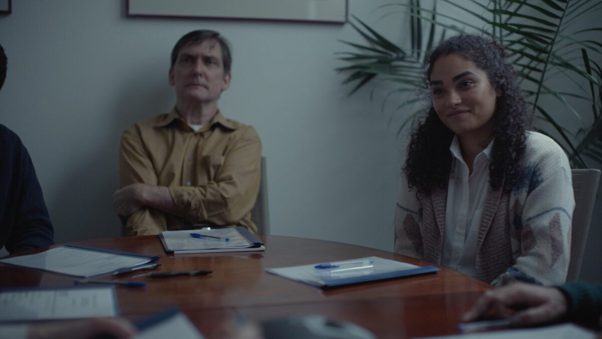 Kadr z sali konferencyjnej, rozmowa przy dużym stole.