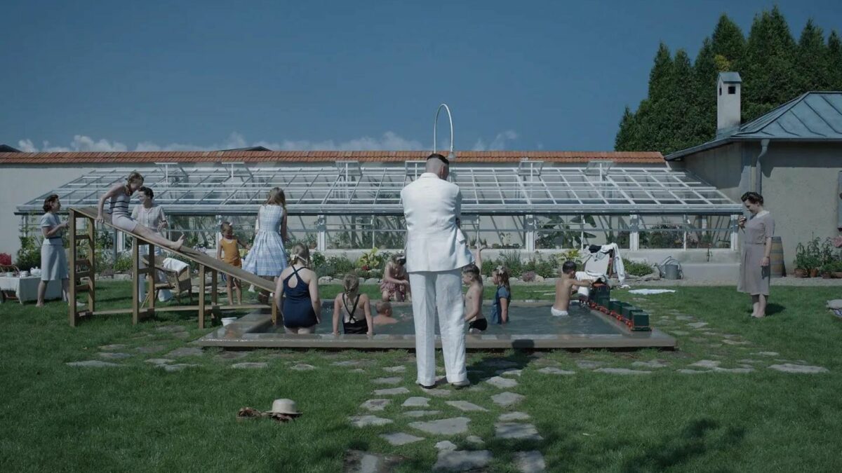 Cała rodzina spędzająca słoneczny dzień w basenie w ogrodzie.