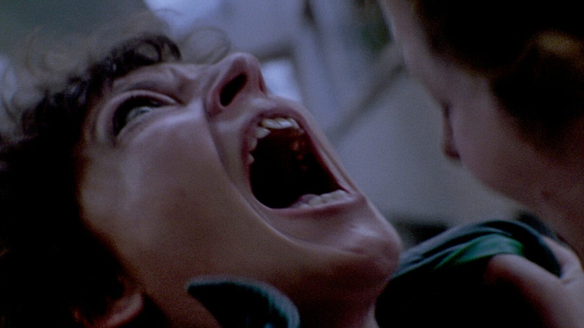 Zbliżenie na krzyczącą, kobiecą twarz.