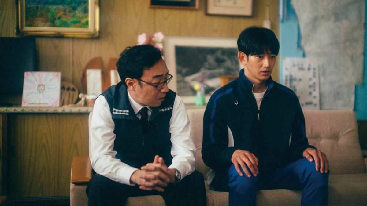 Rozmowa nauczyciela z uczniem w sali lekcyjnej.