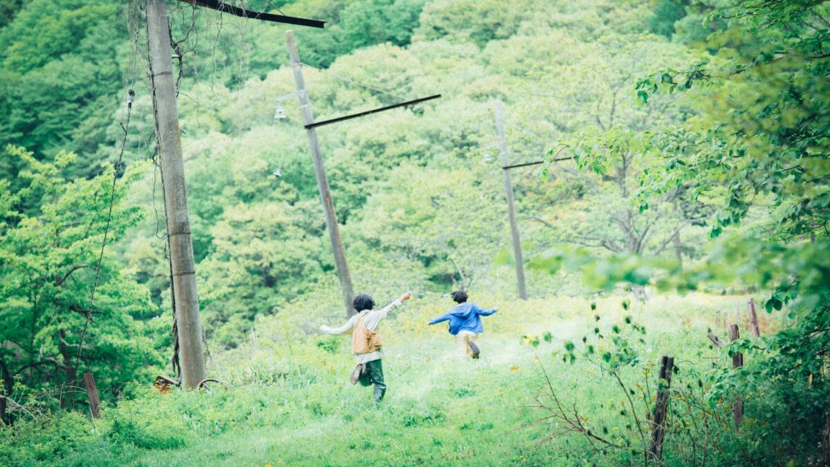 Dwoje dzieci bawiących się na dworze.