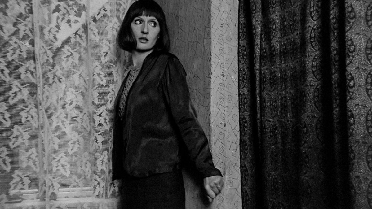 Kobieta chowająca się za ścianą.