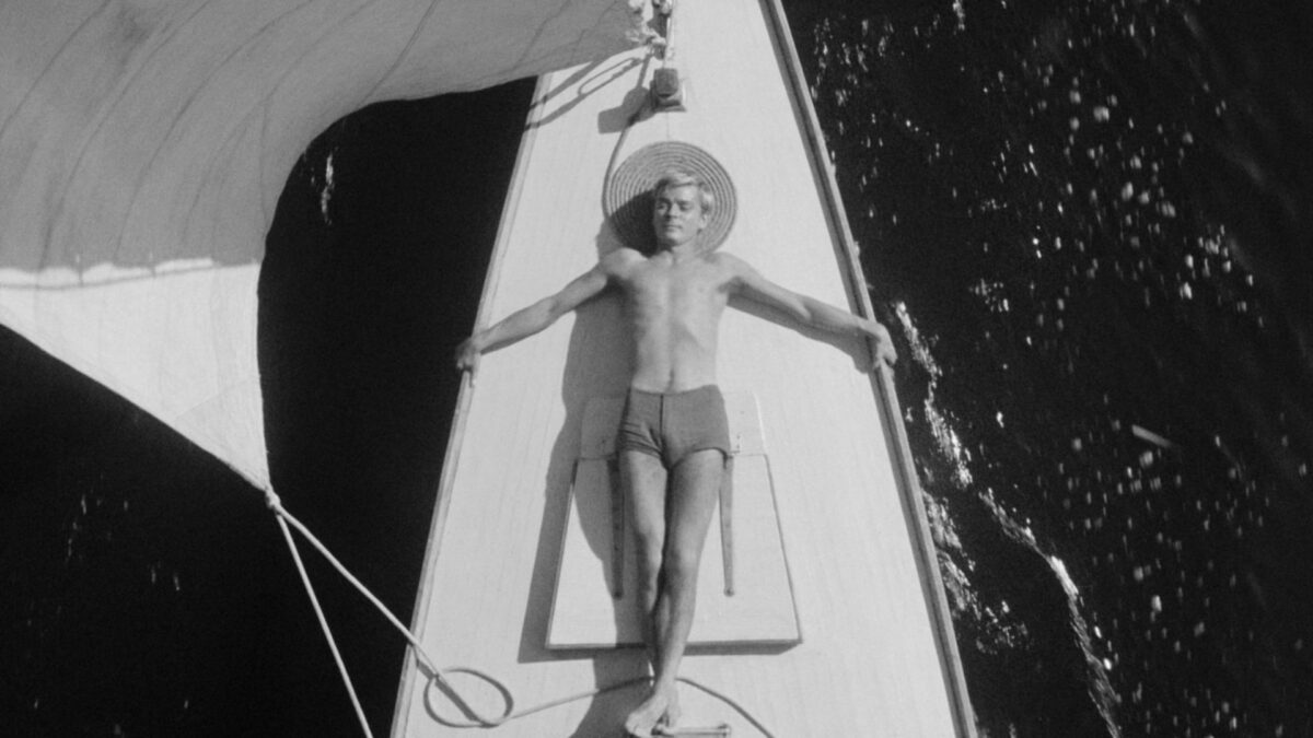 Kadr przedstawiający młodego chłopaka opalającego się na statku.