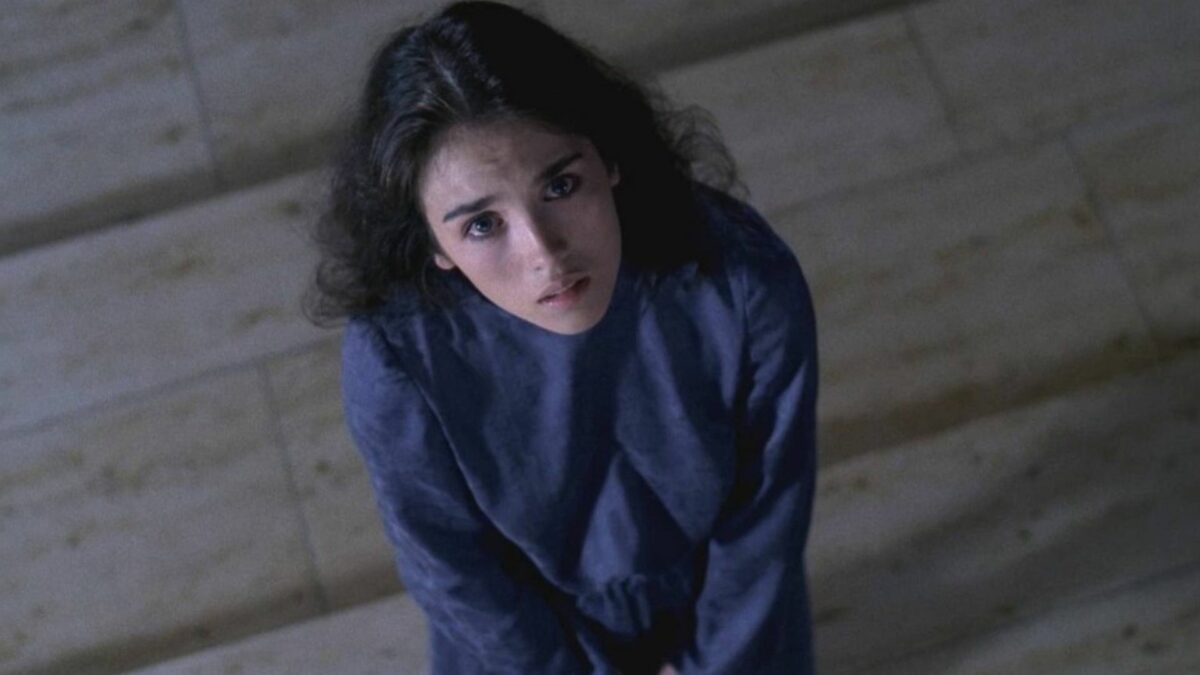 Kobieta siedząca na podłodze, spogląda ku górze.