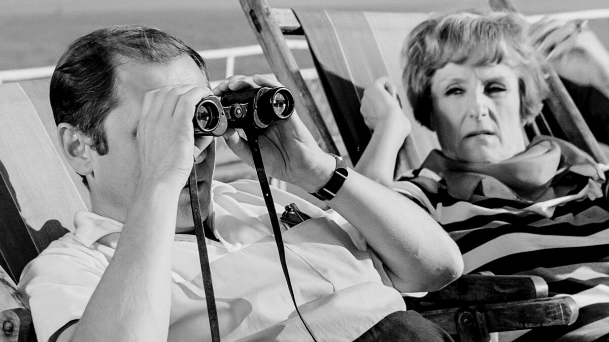 Kadr z filmu REJS przedstawiający mężczyznę na leżaku obserwujący otoczenie z lornetki.