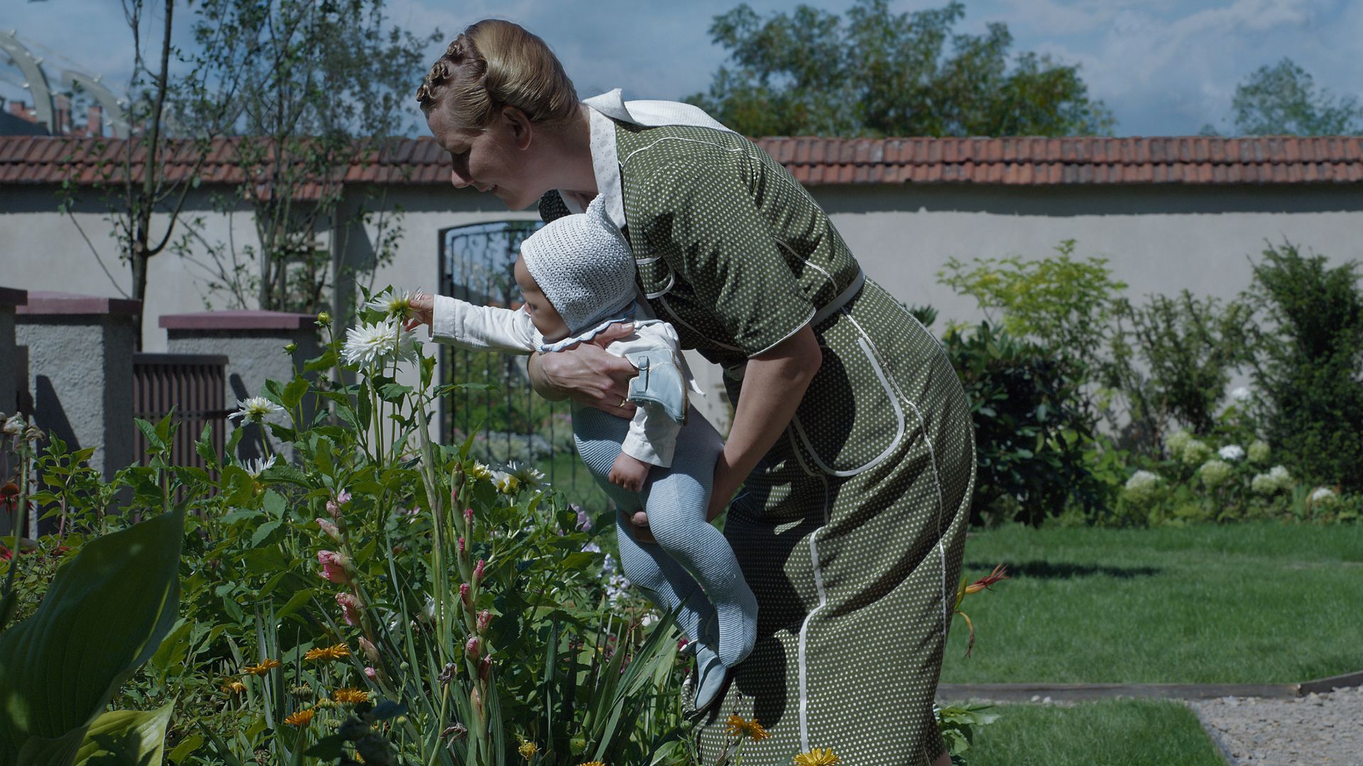Kobieta spędzająca czas z dzieckiem w ogrodzie.