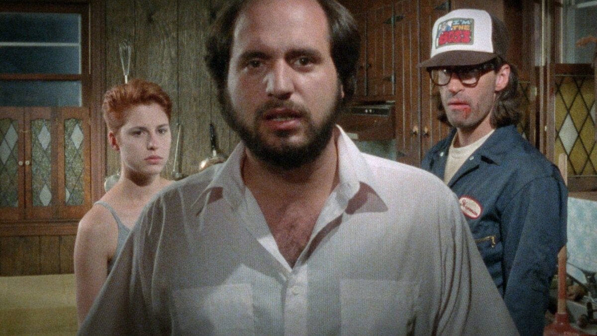 Kadr z głównym bohaterem, za nim stoi chłopak i dziewczyna.