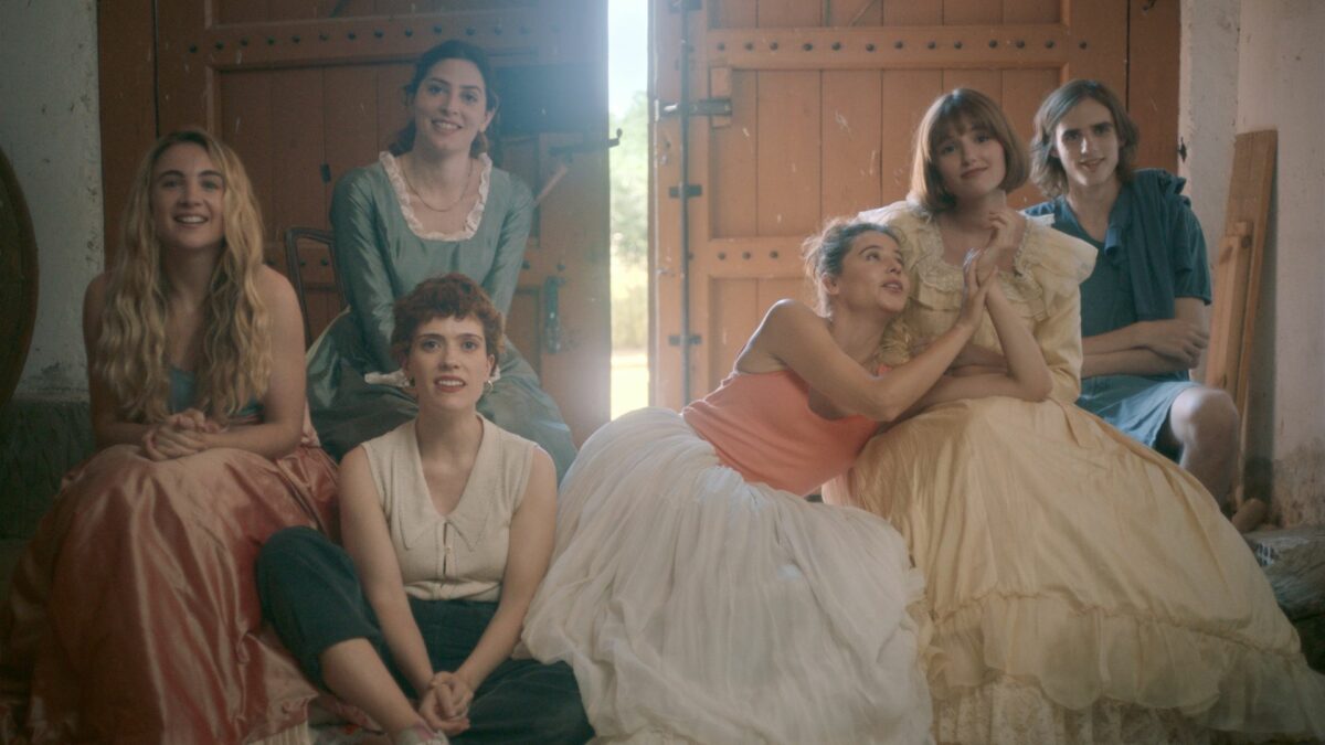 Kadr przedstawia portret pięciu kobiet z chłopakiem stojącym obok.