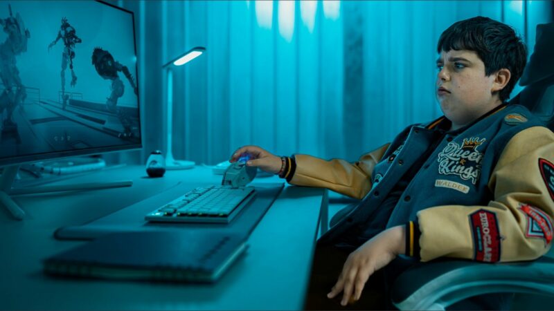 Chłopak przy biurku gra w grę.