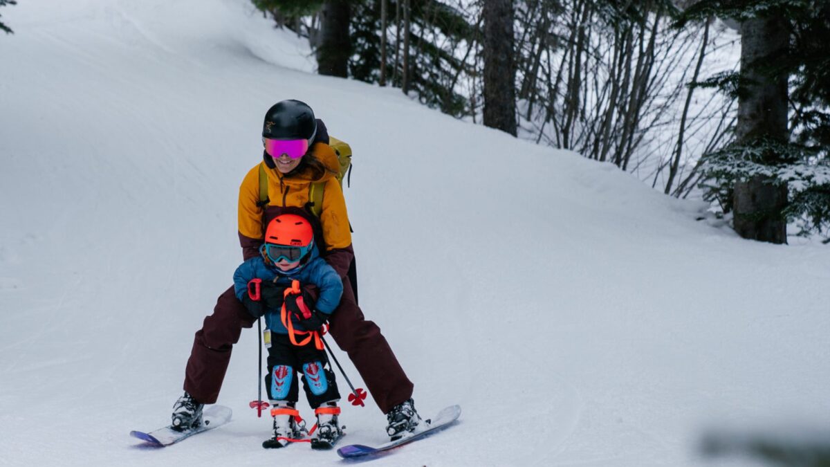 Młoda mama z dzieckiem na stoku narciarskim.