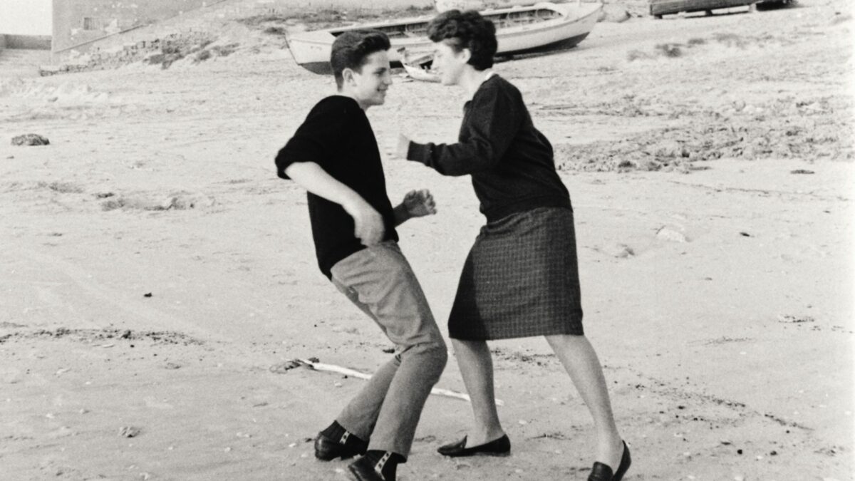 Czarno-biały kadr z mężczyzną i kobietą tańczącymi na plaży
