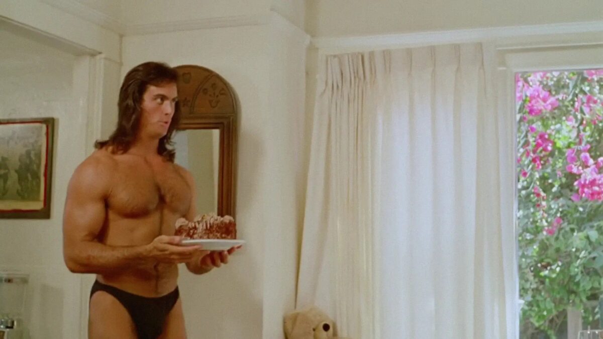 Półnagi mężczyzna przynosi słodkie ciasto.