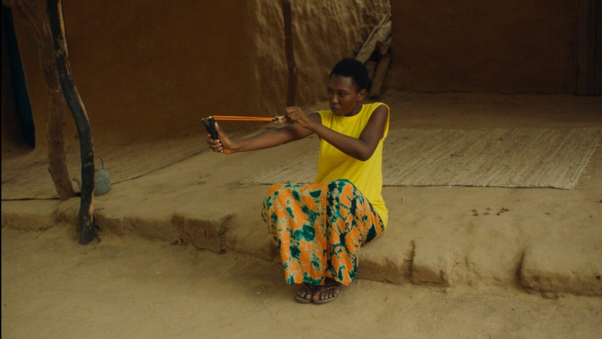 Kobieta celuje z procy w nieznany obiekt.