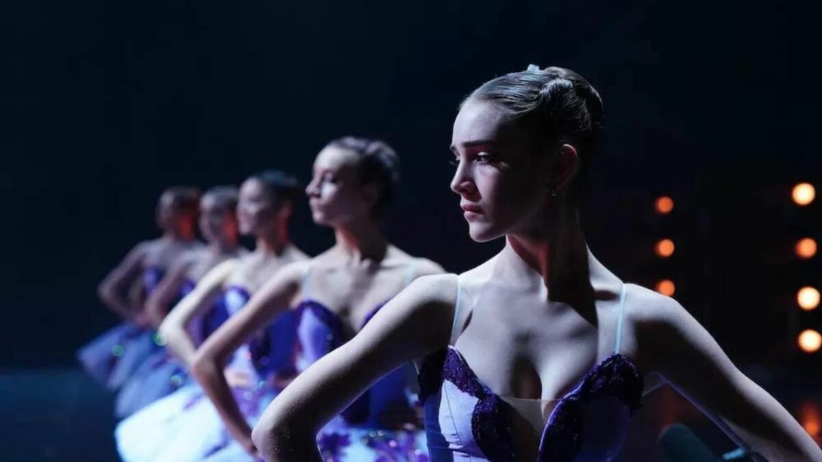 Grupa tancerek na scenie podczas pokazu baletowego.