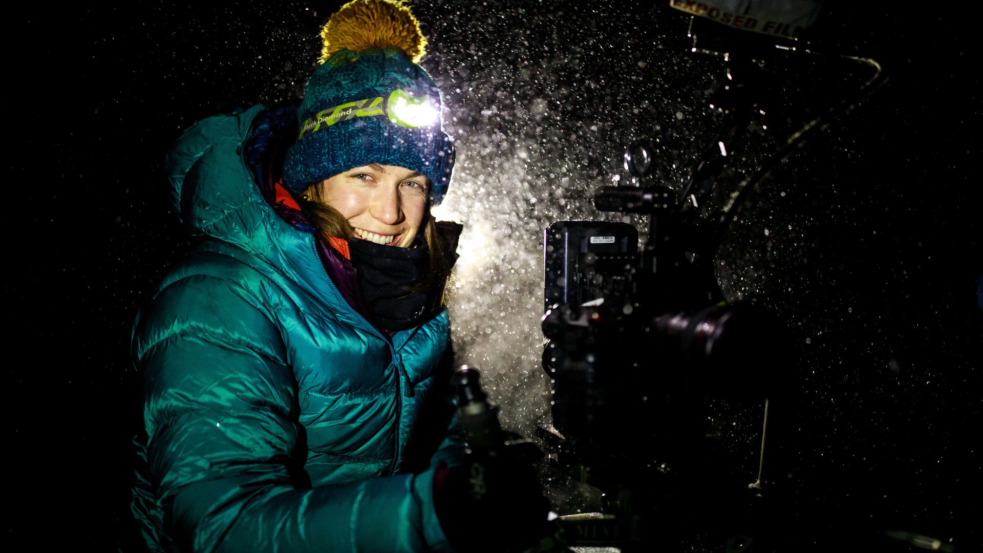Reżyserka filmu przy kamerze w zimowych, górskich warunkach.