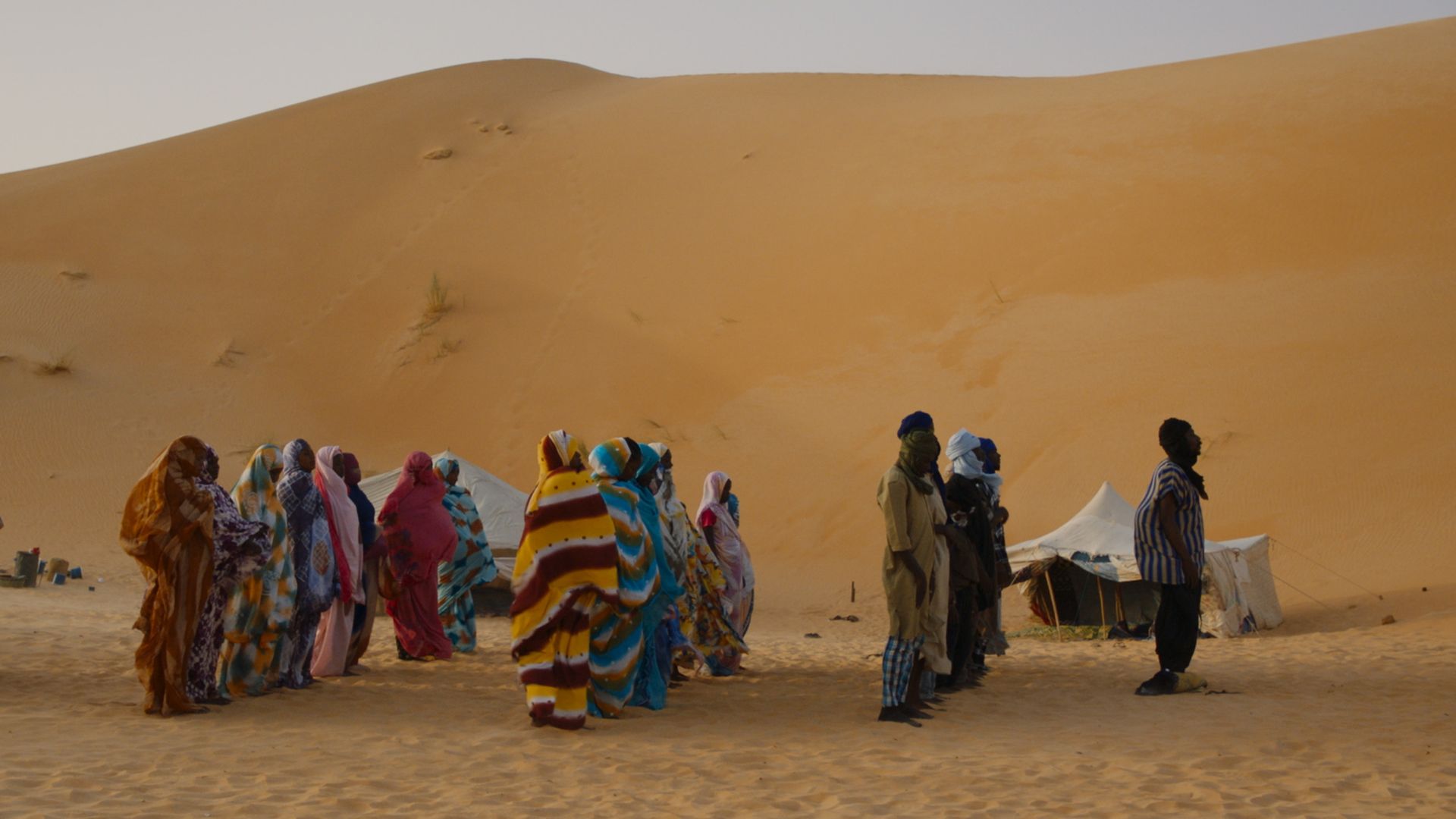 grupa ludzi na afrykańskiej pustynia, w strojach tego regionu.