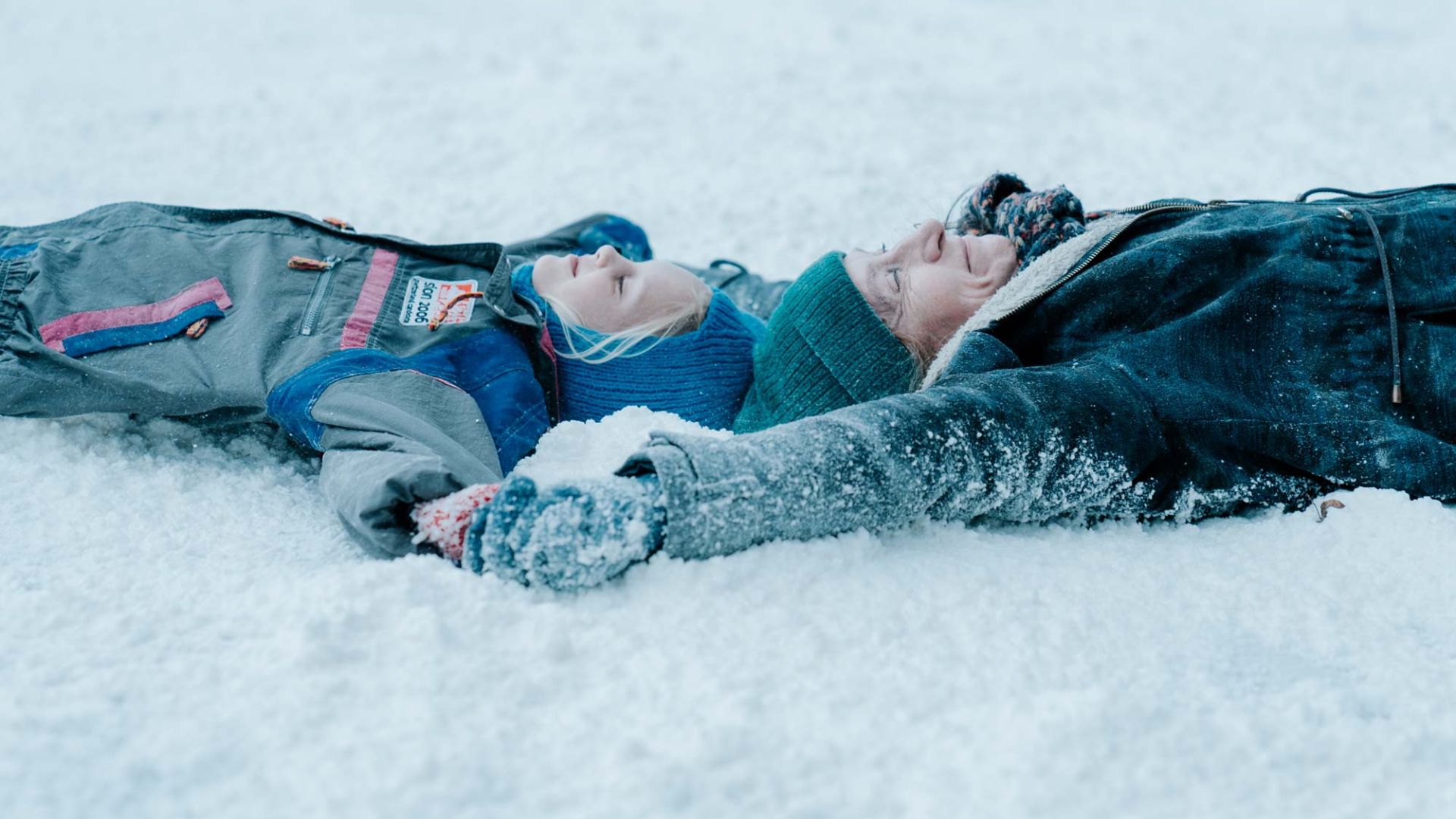 Dwie przyjaciółki leżą na śniegu.