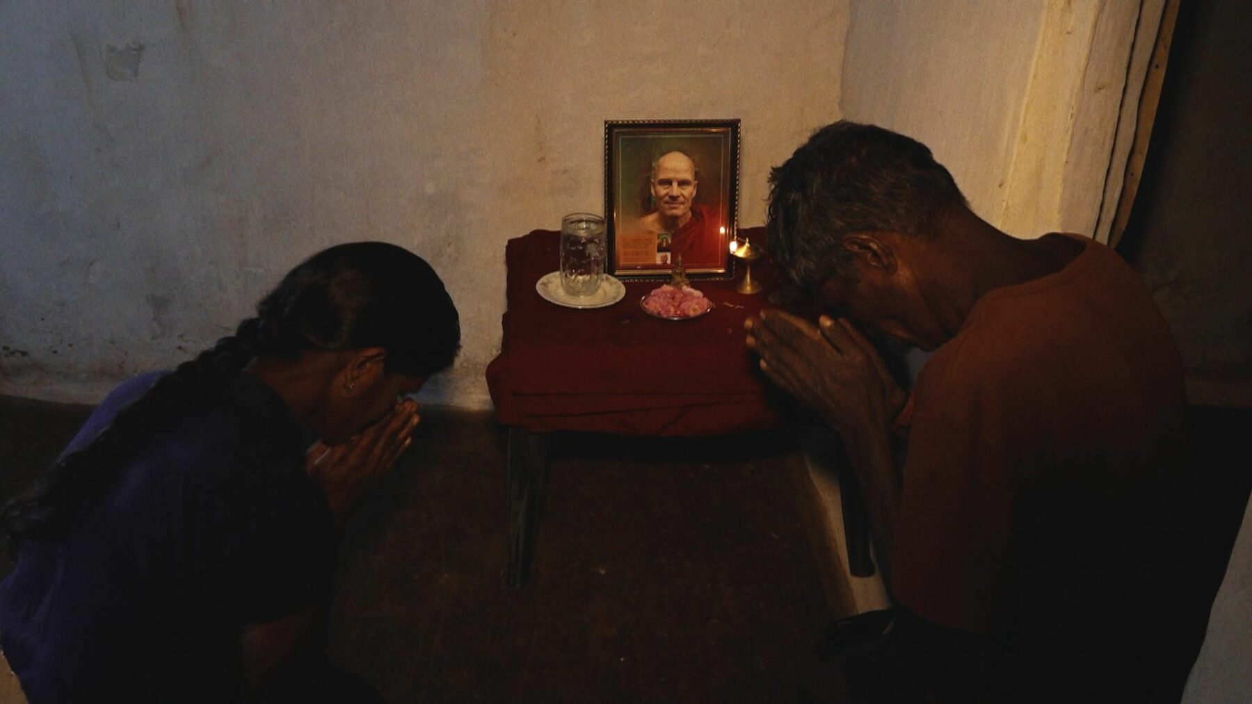Dwie osoby modlą się przed ołtarzykiem