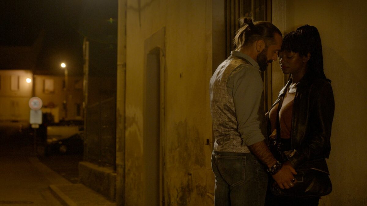 Miasto nocą, para w wąskiej, opustoszałej uliczce.