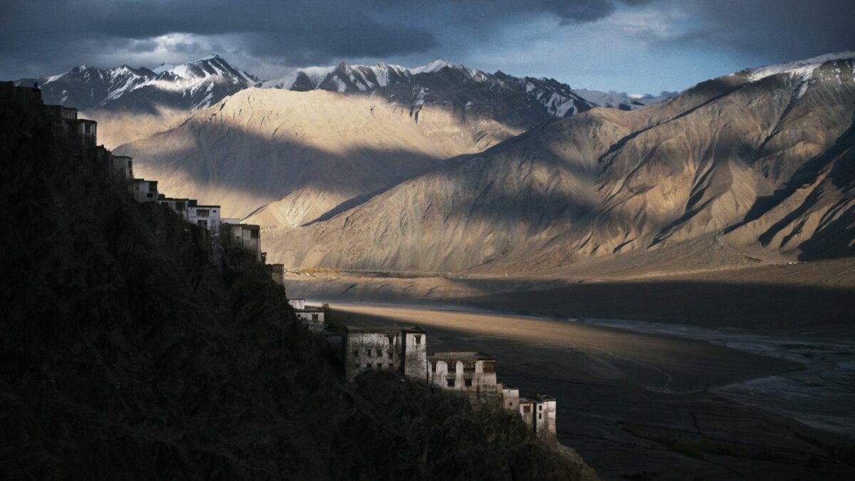 Krajobraz osnuty cieniem ze szczytami górskimi i miasteczkiem położonym wśród gór