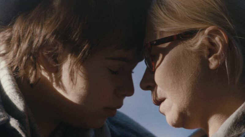 Dziewczyna z zamkniętymi oczami styka się czołem ze starszą kobietą w okularach przeciwsłonecznych