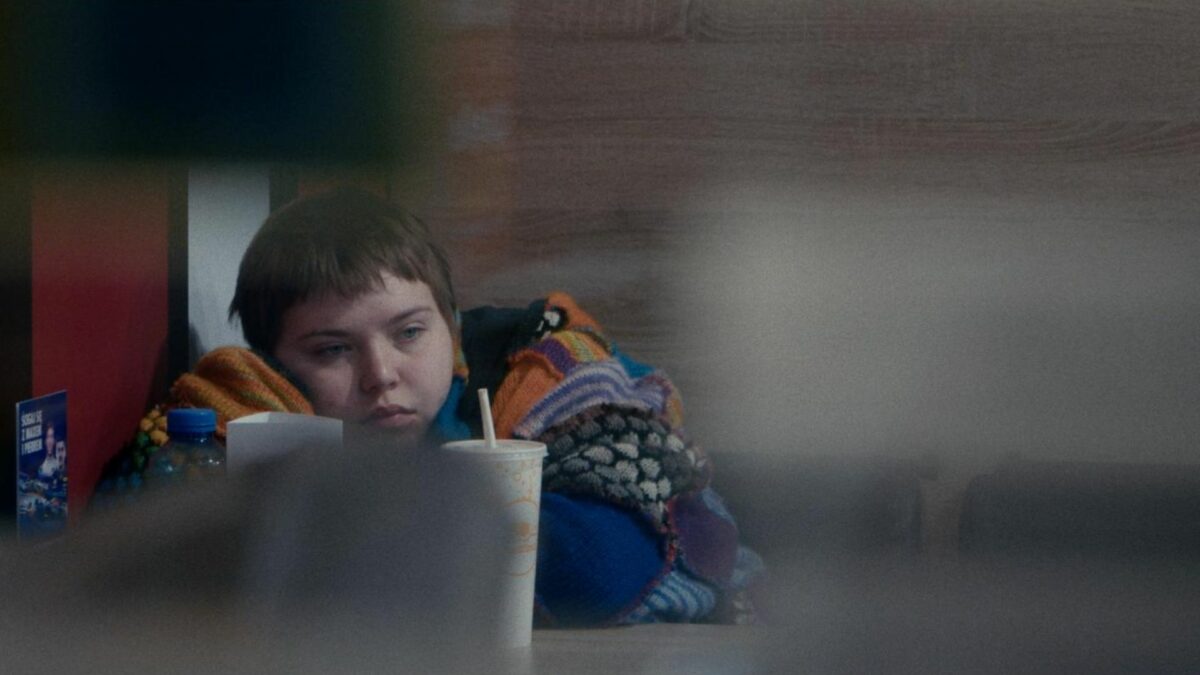 Przygnębiona dziewczyna siedzi z podpartą głową w restauracji