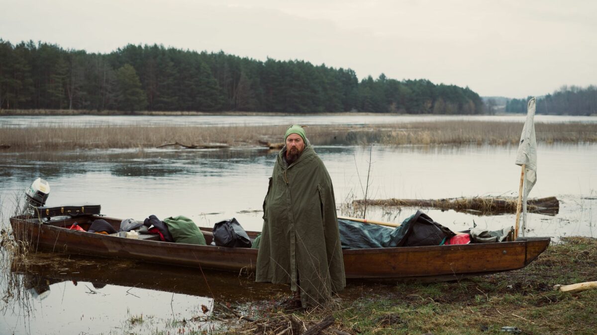 Mężczyzna stoi przy łodzi wypełnionej ekwipunkiem