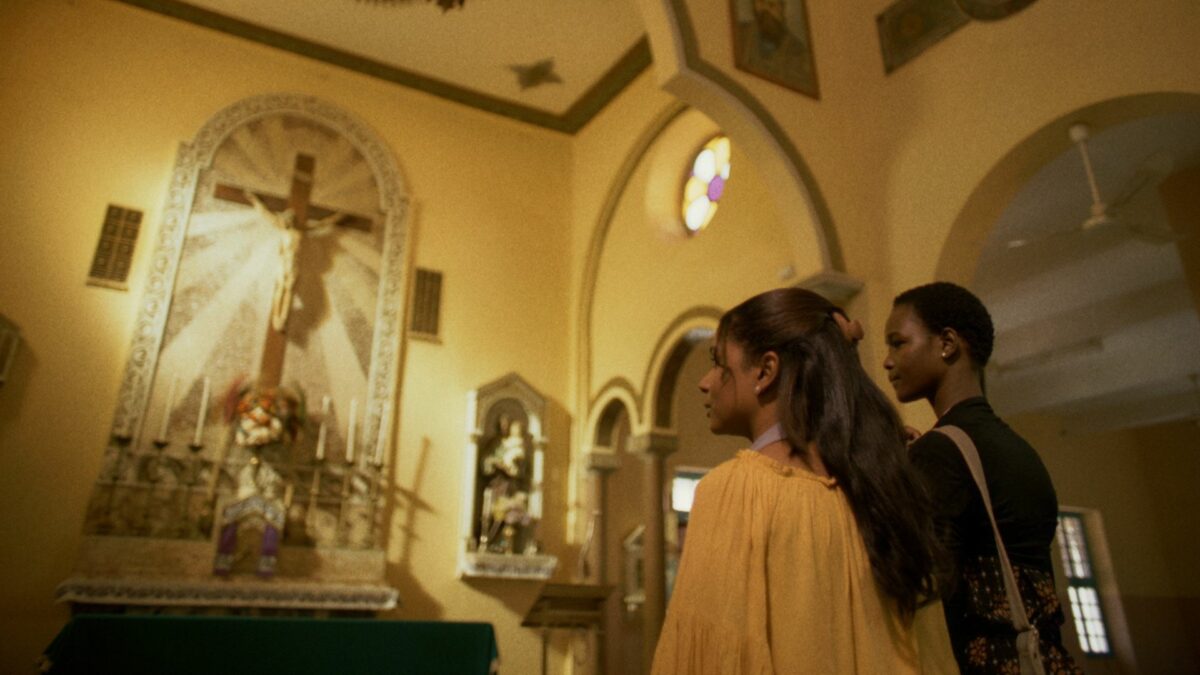 Dwie kobiety w kościele, stojące przed ołtarzem.