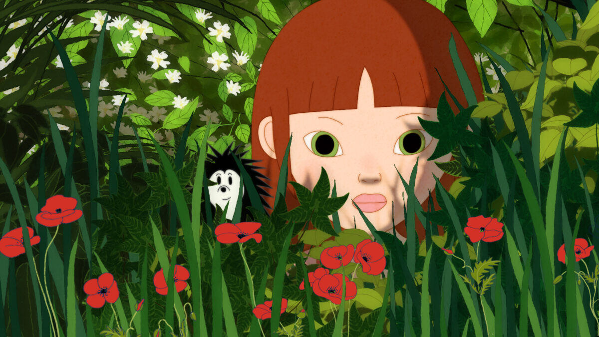 Kadr z bajki przedstawiający dziewczynkę z jeżem w leśnej trawie.