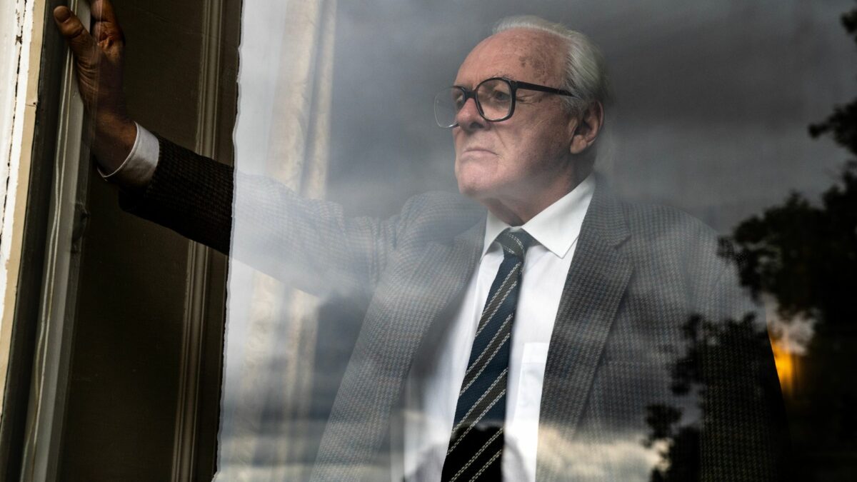 Zbliżenie na starszego mężczyznę za oknem.