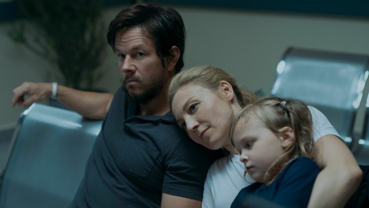 Rodzina w poczekalni, mężczyzna przytula córkę i żonę.