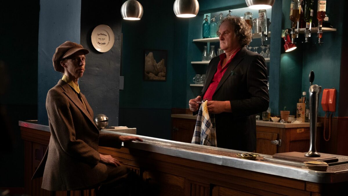 Kadr z baru, za ladą mężczyzna składający zamówienie u barmana.