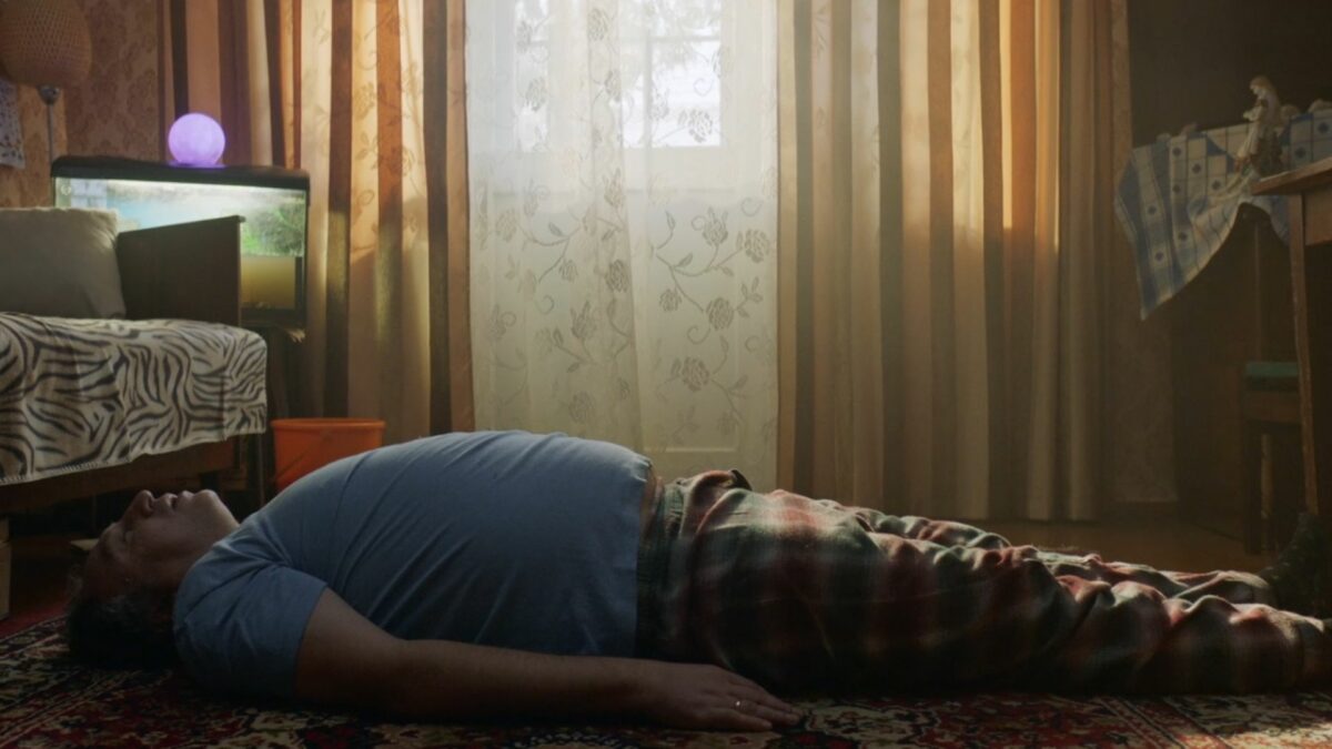 Ojciec rodziny leżący na podłodze w pokoju.