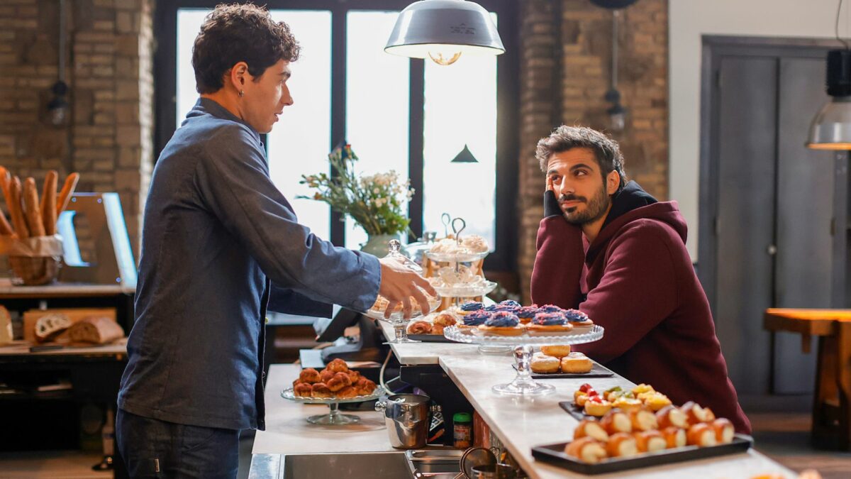 Kadr z cukierni i widok na kucharza i chłopaka za barem.