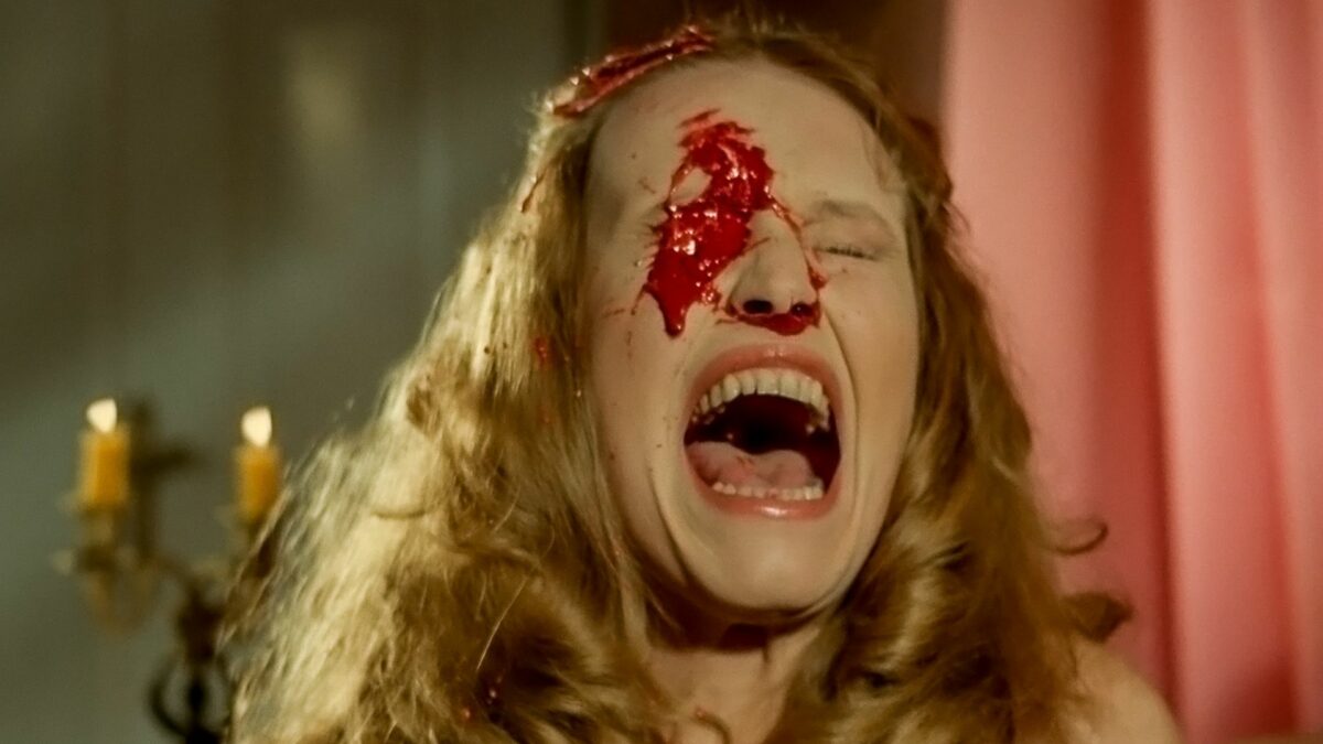 Kadr z przerażoną i zakrwawioną kobietą.