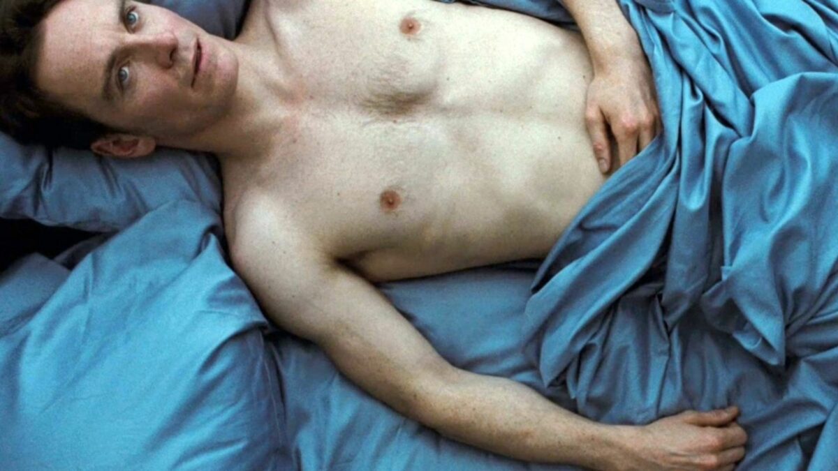 Mężczyzna w niebieskiej pościeli.