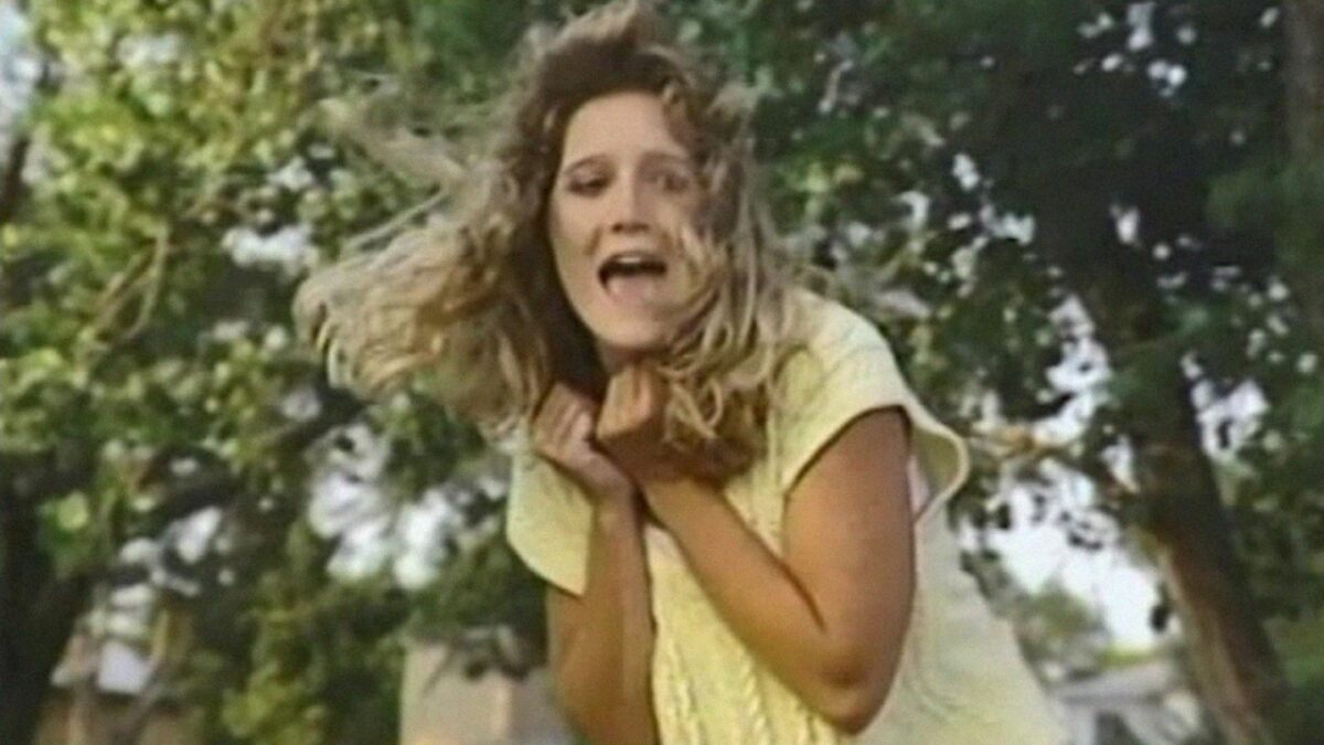 Przerażona dziewczyna ucieka przez las.