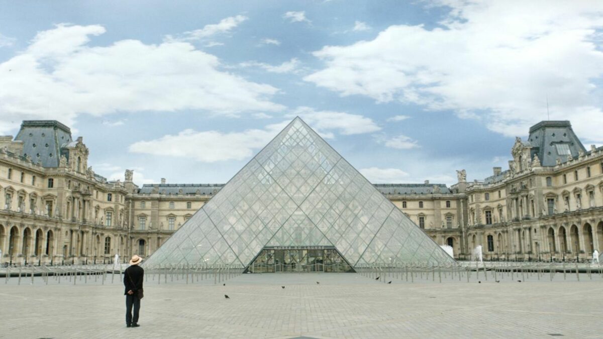 Mężczyzna na tle paryskiego muzeum.