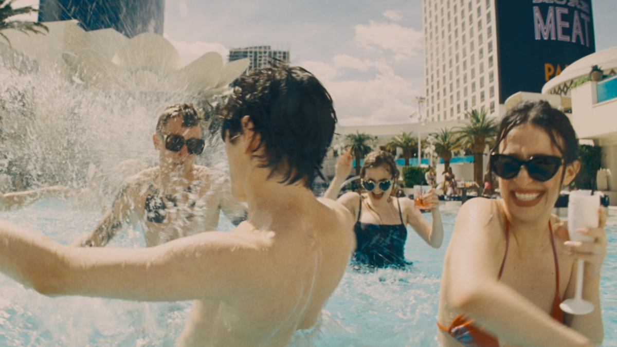 Grupa młodych ludzi imprezujących w basenie.