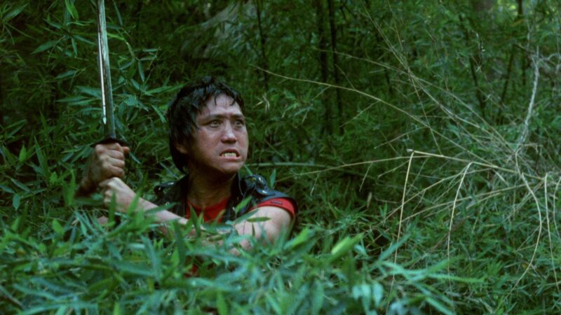 Skradający się mężczyzna z mieczem w dłoni.