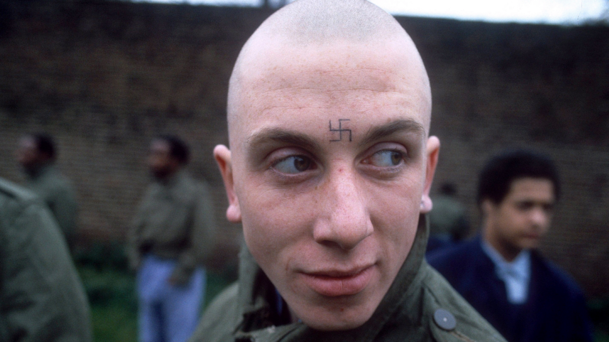 Mężczyzna na zlocie bojówkarzy, w tle widać innych meżczyzn.