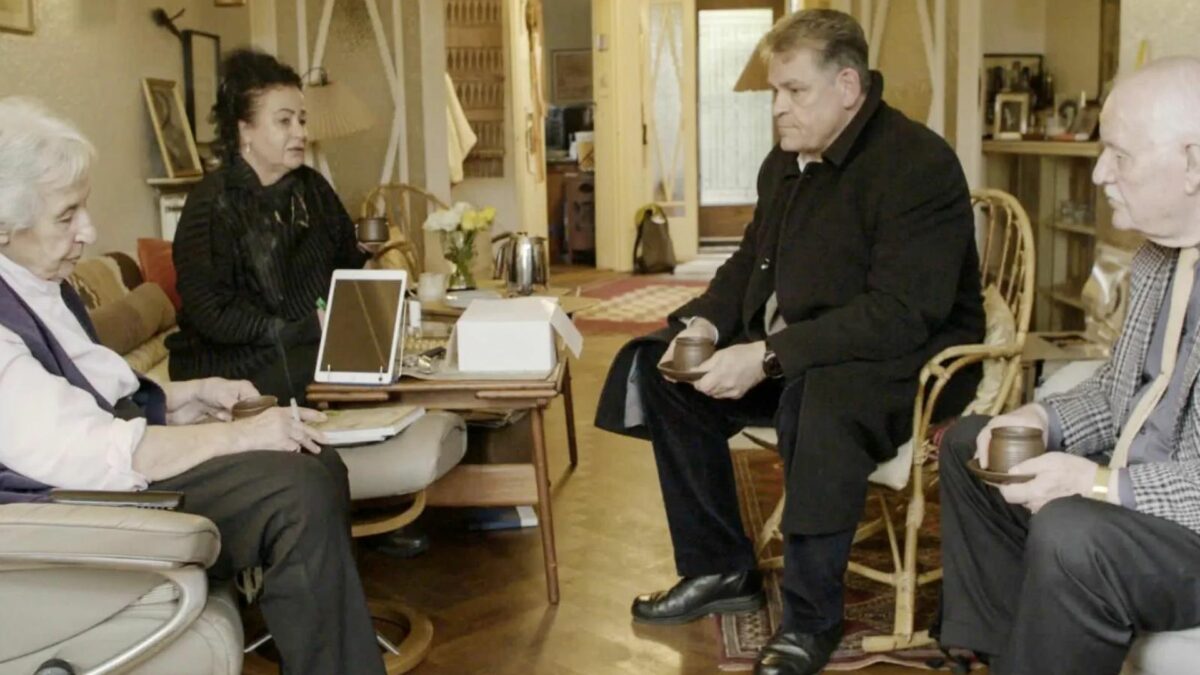 Mężczyzna prowadzi rozmowę ze starszymi osobami.