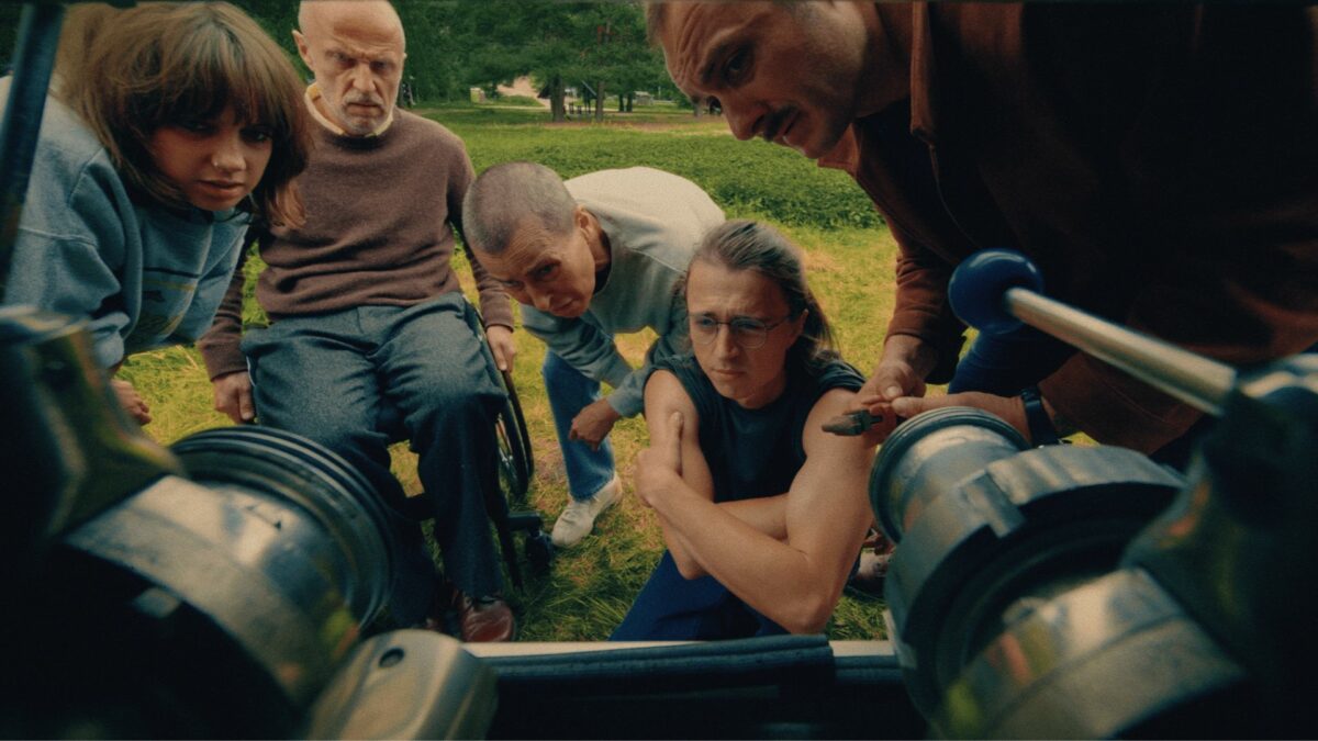 Grupa ludzi zaglądająca do przyczepy furgonetki.