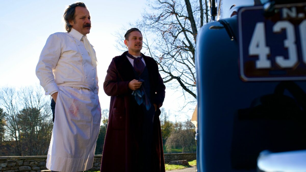 Kadr przed domem i zaparkowanym samochodem a przed nim szofer i kucharz.