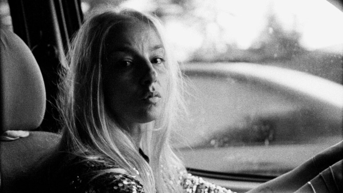 Kobieta w samochodzie na miejscu kierowcy spoglądająca na pasażera.